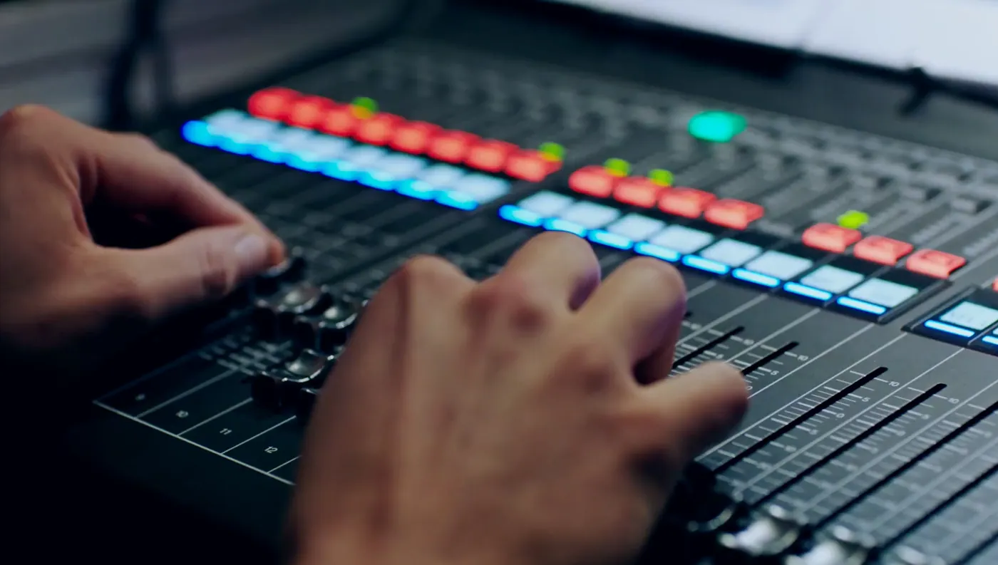 Engineer's hands on a digital mixing console during a live show